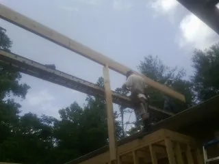 Carpenter setting a ridge beam over a new addition frame — Ice Dam Removal by Roofing Brothers in East Galesburg