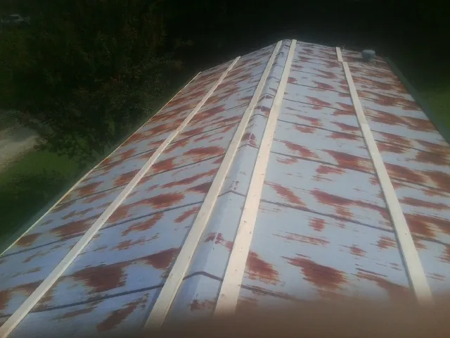 Rusted metal roof panels with new wood purlins before replacement — Storm Damage Roof Repair in East Galesburg by Roofing Brothers
