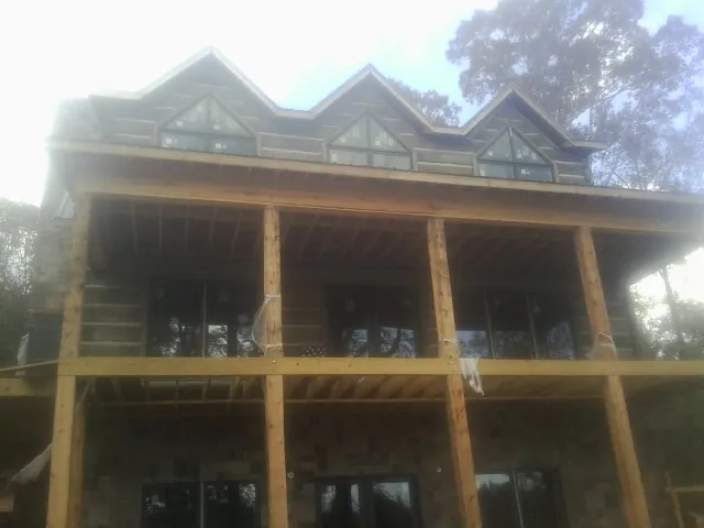 Dormers and porch framing on a large log home under construction — Roof Coating work by our crew in East Galesburg