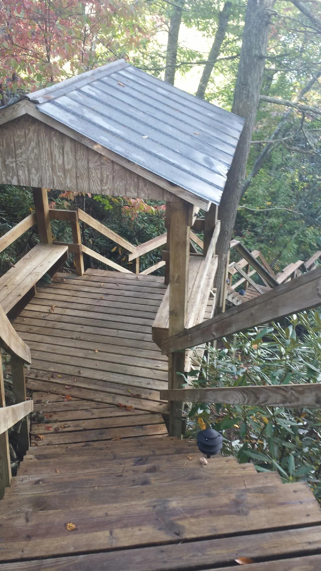 Metal roofed shelter over wooden steps on a wooded walkway — Skylight Repair & Installation work by our crew in East Galesburg