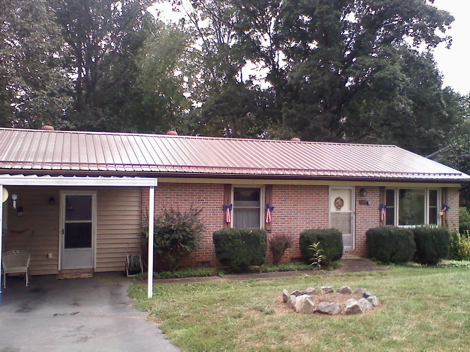 Bronze metal roof and carport on a brick ranch home — Roof Repair work by our crew in East Galesburg